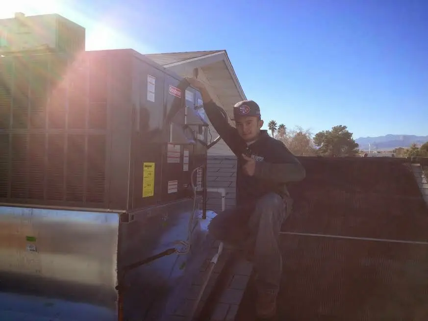 HVAC technician performing Air Duct Cleaning on a rooftop unit in University Park